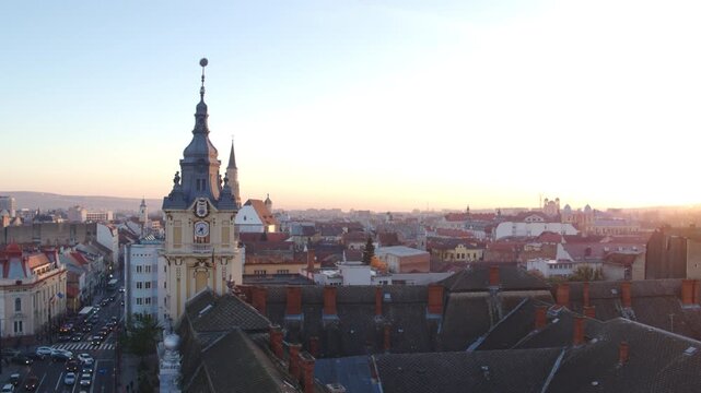 Wide aerial shot panning across the historic Cluj-Napoca skyline in Romania, St. Michael's Roman Catholic Church and the clock tower