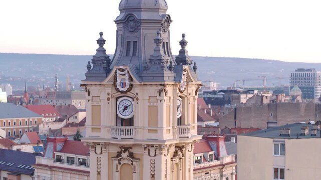 Medium aerial shot panning around the ornate City Hall clock tower in Cluj-Napoca