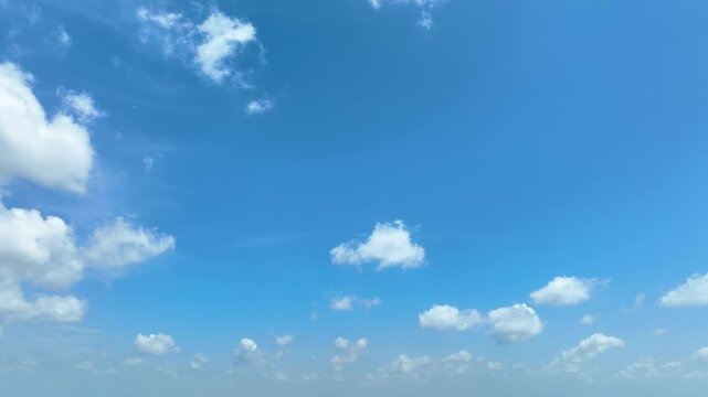 Aerial drone view panning sideways across a brilliant blue sky with drifting white clouds, symbolizing travel, exploration, new destinations, limitless opportunities, hope, and forward momentum. 4k.
