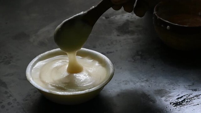 pure desi ghee in wooden bowl on black background