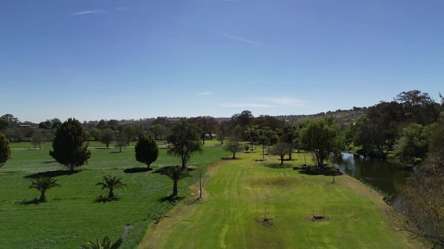 Aerial view of a private golf course fairway leading toward a curved lake surrounded by trees in a luxury residential community in central Mexico.