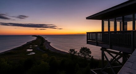 Obraz premium Seaside Sunset View from Modern Balcony Overlooking Ocean and Coastline at Dusk.