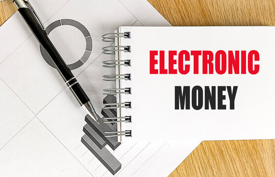 Electronic money concept on notepad with financial charts and pen on wooden desk representing digital payments