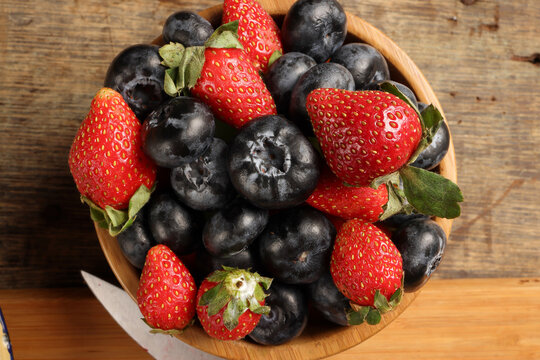 Strawberry blueberry in wooden bowl on rustic wooden background
