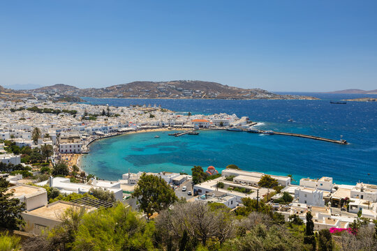 Stunning views of Mykonos island in Greece. Featuring iconic whitewashed architecture, narrow streets, historic windmills, and the sparkling Aegean Sea under a bright summer sky.