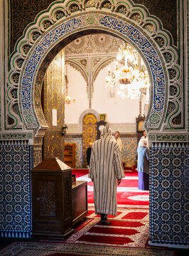 Man in traditional djellaba enters ornate mosque