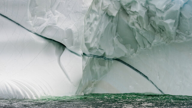 Close up of a massive iceberg floating in ocean off Newfoundland