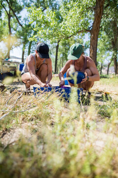 Two women friends wash dishes at their campsite