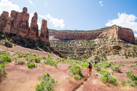 Woman trail running through a scenic desert canyon
