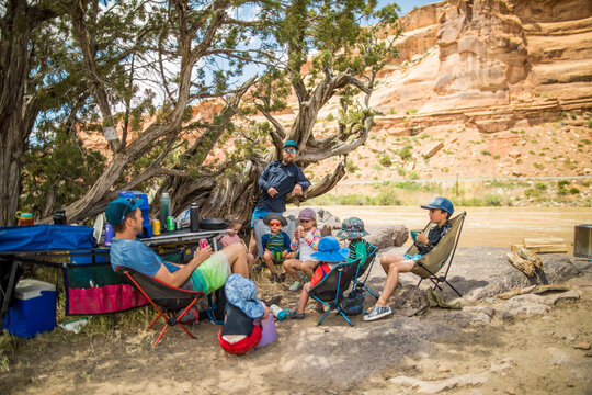 Family and friends relaxing at a riverside campsite