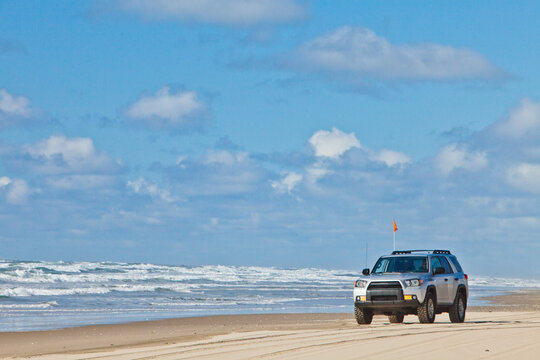 Silver sport utility vehicle driving on the beach