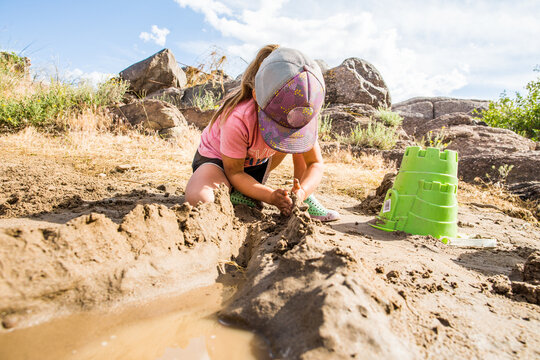 Little girl having fun playing in the mud