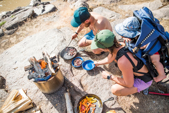Overhead view of family cooking dinner over fire outdoors
