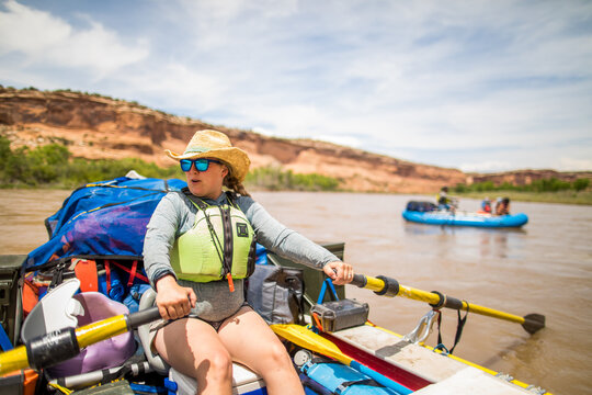 Female guide rowing a large raft on a desert river
