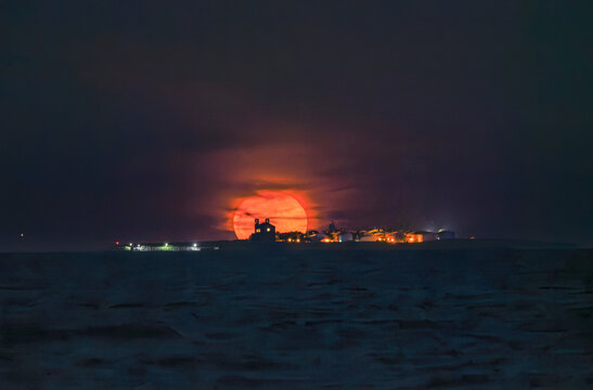 Golden blood moon rising over the silhouette of Tabarca Island