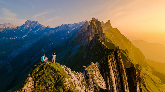 Schaeffler mountain ridge, Swiss Alpstein, Appenzell, Switzerland, ridge of the majestic Schaeffler peak by Berggasthaus Schafler, Switzerland. couple of men and women in the mountains during sunset
