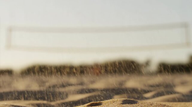 Low-angle beach volleyball impact with sand spray under warm golden hour light, with volleyball, sand, impact, spray detail, showing particle, plume, grain, beach context