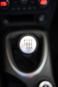 Top down close up shot of a 6 speed manual gear shift knob inside the modern center console of a car cockpit