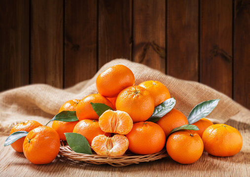 Plate of fresh mandarin oranges fruit or tangerines on a wooden background