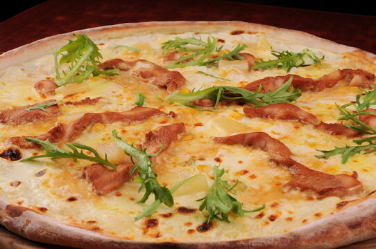 Chicken and Pineapple Pizza with Fresh Greens on Wooden Table