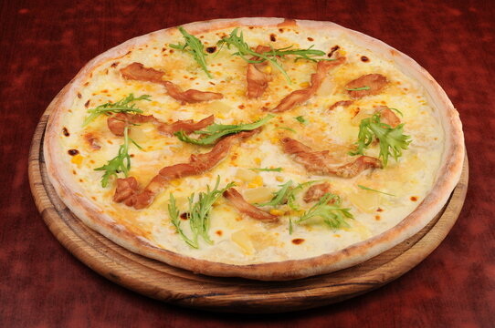 Thin Crust Pizza with Bacon and Arugula on Wooden Board