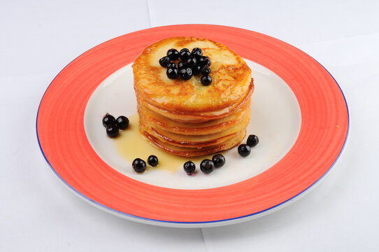 Stack of Pancakes with Blueberries and Syrup on Plate