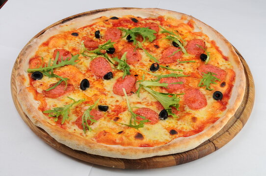 Pepperoni Pizza with Arugula and Olives on Wooden Board