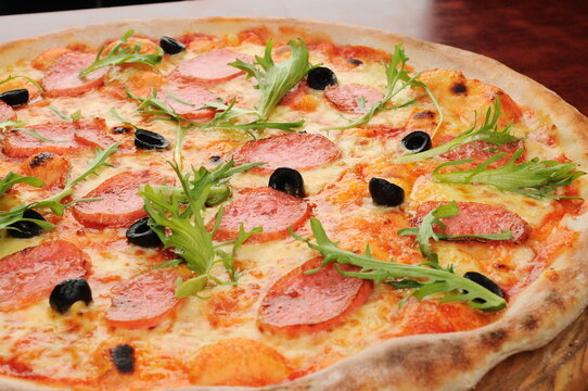 Pepperoni and Arugula Pizza on Wooden Board