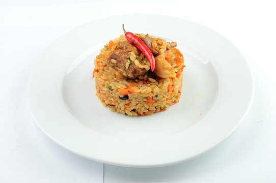 Plov Rice Dish with Meat and Chili Pepper on Plate