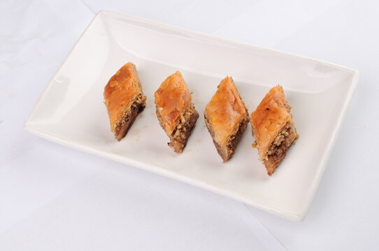 Four Pieces of Traditional Baklava on a White Plate
