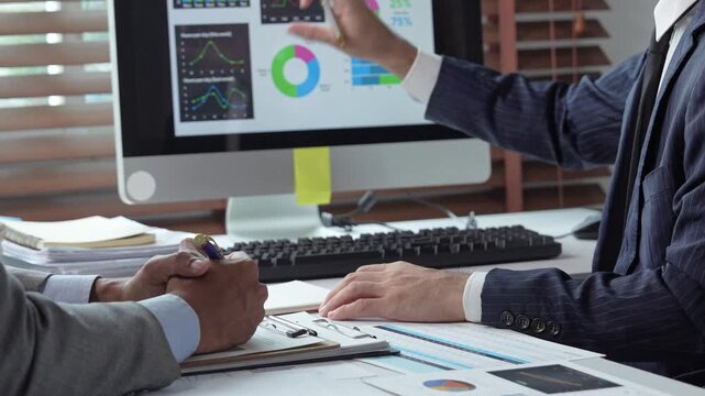 Businessmen analyzing financial data charts in an office meeting