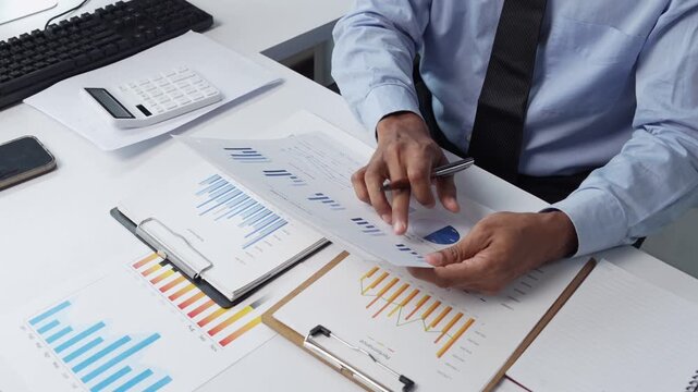 Businessman analyzing financial reports and business data