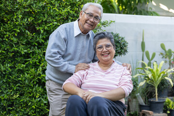 Fototapeta premium Happy smiling senior asian couple portrait standing together outdoor green garden enjoying peaceful retirement lifestyle surrounded lush nature foliage relaxing warm afternoon