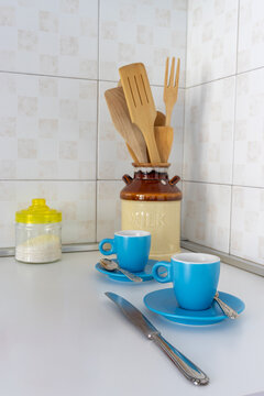 Elegant kitchen still life with apple, coffee cups and wooden utensils