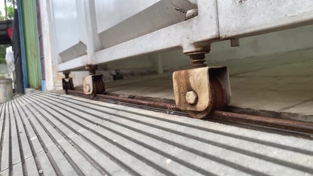 Close Up of Rusty Rolling Shutter Door Wheel Track in Motion &mdash; Ideal for Industrial and Hardware Footage