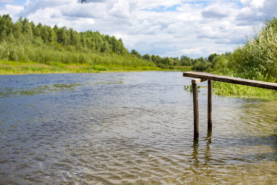 A bridge for jumping into the water has been installed on the bank of a small river.