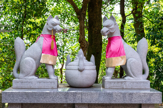 Kitsune fox statues guarding inari shrine in japan