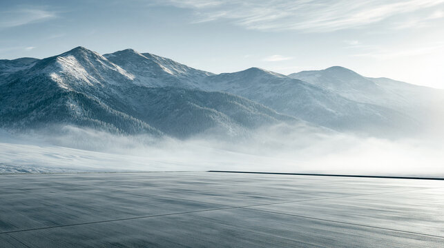  Leere Asphaltfl&auml;che als Mockup-Hintergrund mit verschneiten Bergen und Nebel im Winter.