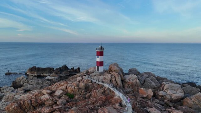 Phu Yen, Vietnam - June 26, 2026: Drone footage captured with a wide-angle lens flying from inland toward Ganh Den Lighthouse in Dak Lak (formerly Phu Yen) Province, Vietnam. The lighthouse remains ce