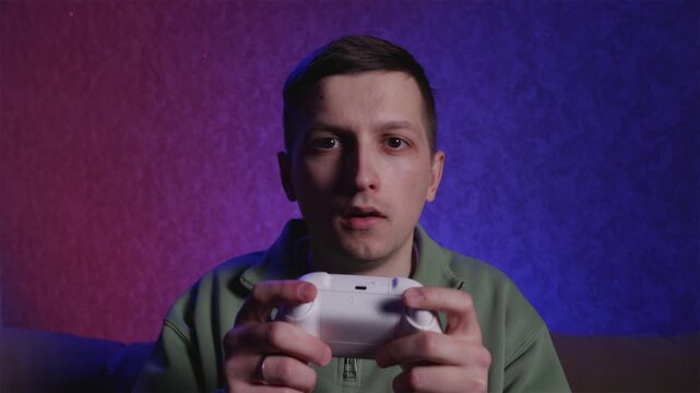 Young gamer playing video games with controller actively