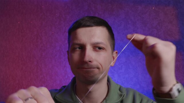 Young man using dental floss for oral hygiene routine