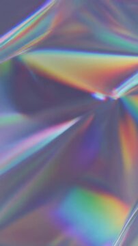 Macro view of holographic diffraction film displaying flowing rainbow colors and spectral reflections under soft studio lighting, creating a refined futuristic abstract background.