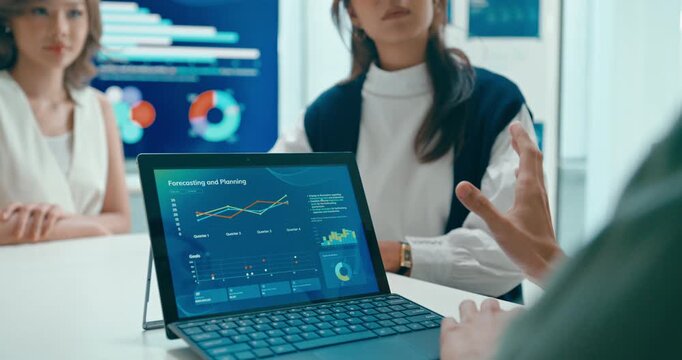Closeup group Asian businesspeople work together discuss plan idea with investment profit sale statistics in business meeting in office. Financial generation z team brainstorm on e-Commerce project.