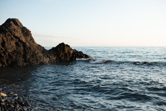 Nature background with open sea water and rocks at coast line. Summer vacation time.