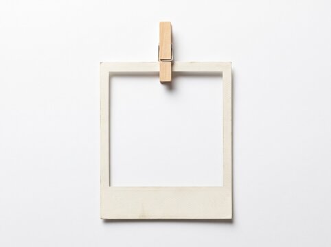 Blank vintage Polaroid photo frame with wooden clothespin isolated on white background. Realistic instant picture mockup template for memory scrapbook or gallery display. Retro empty paper photo frame