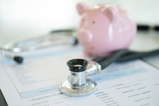 Investment in health insurance and financial planning for health concept. piggy bank, medical stethoscope and medical expenses bill.