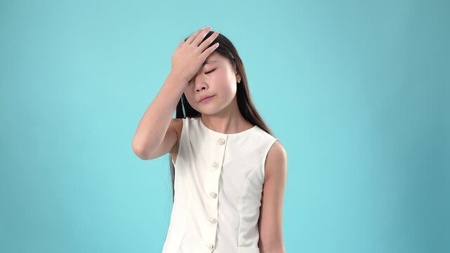Frustrated asian child making a facepalm gesture due to a silly mistake