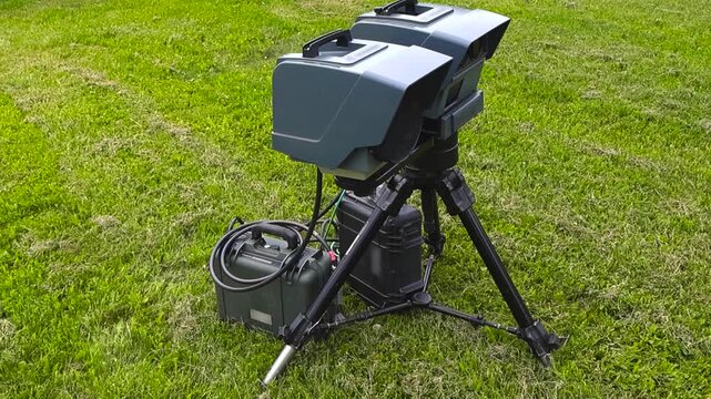 Modern police lidar speed camera on a tripod measuring traffic velocity for law enforcement, a crucial tool for road safety enforcement and issuing fines for speeding violations