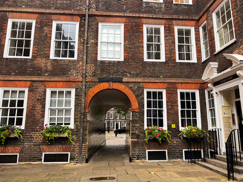 Historic brick buildings in London Temple district with elegant white sash windows and flower boxes, timeless Inns of Court architecture, prestigious legal quarter, classic British heritage