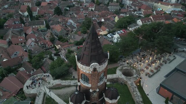 Drone rotates around the Gardos tower, capturing a high-angle close-up of its distinctive conical roof at dusk, Zemun, Belgrade, Serbia.